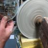 Wheel grinding away the edge of the glass Wheel grinding away the edge of the glass